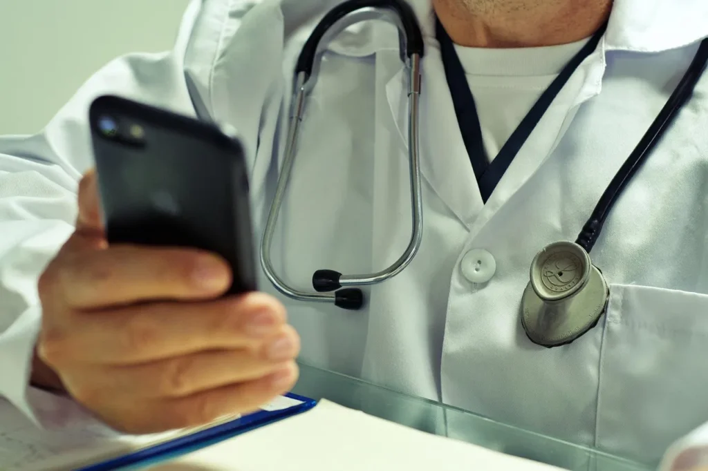 Online doctor providing telehealth consultation via smartphone